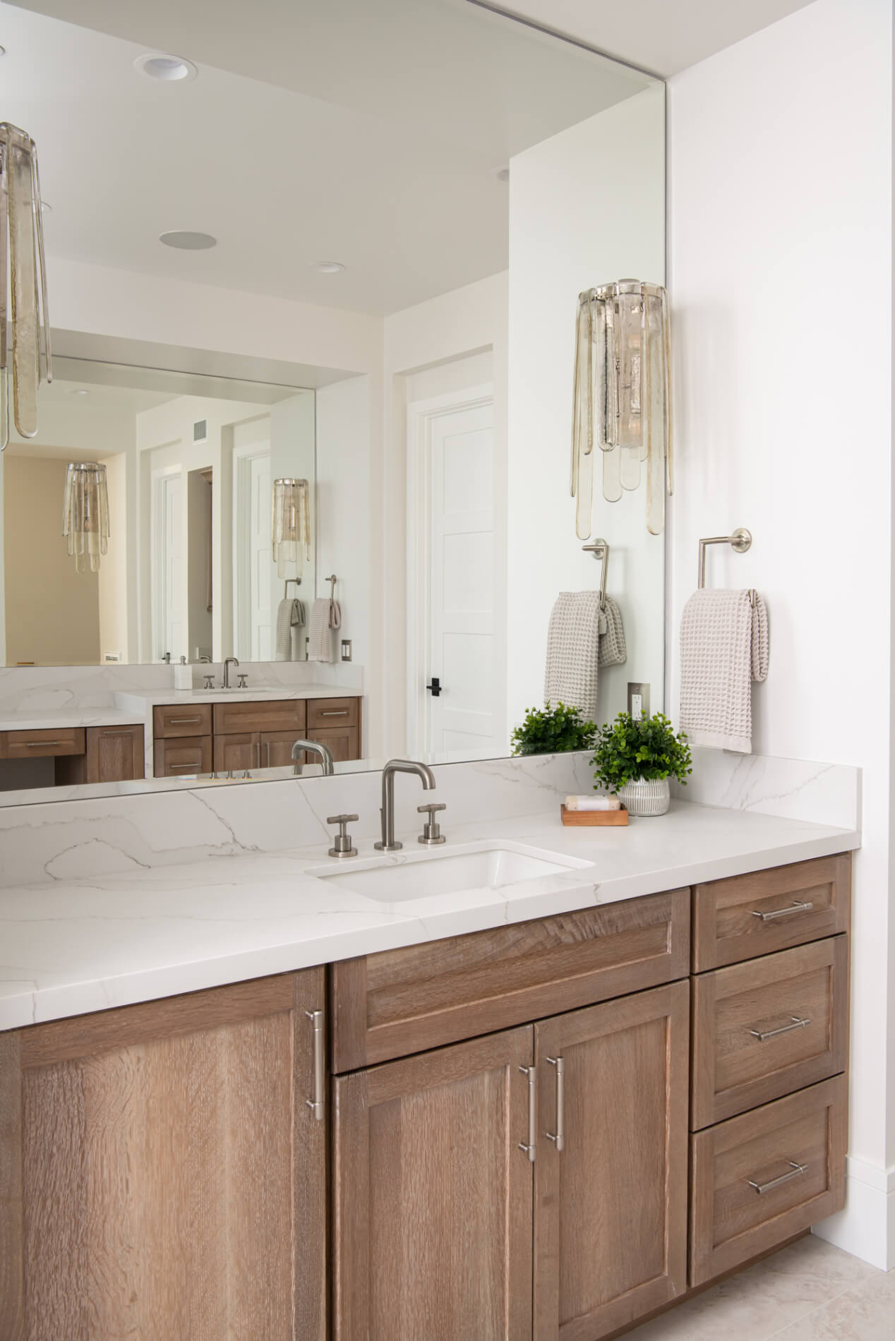 Cerused oak vanity straight-on with marble top and frameless mirror