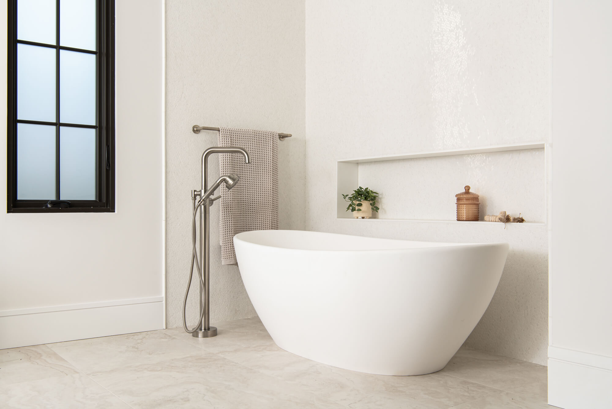 Modern organic bathroom remodel in Duluth with fan-pattern mosaic wall and egg tub