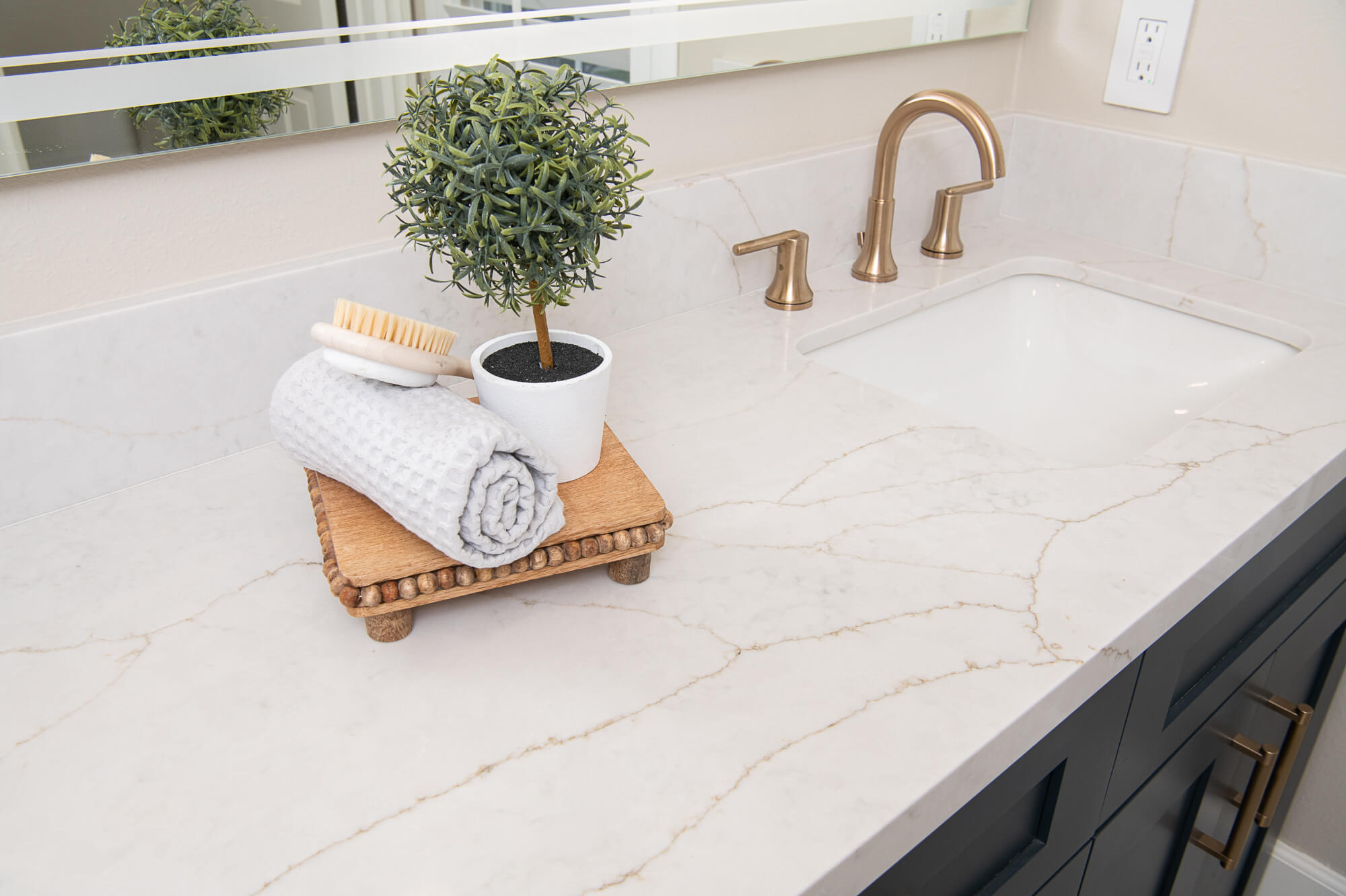 Calacatta marble counter macro with brass faucet and topiary