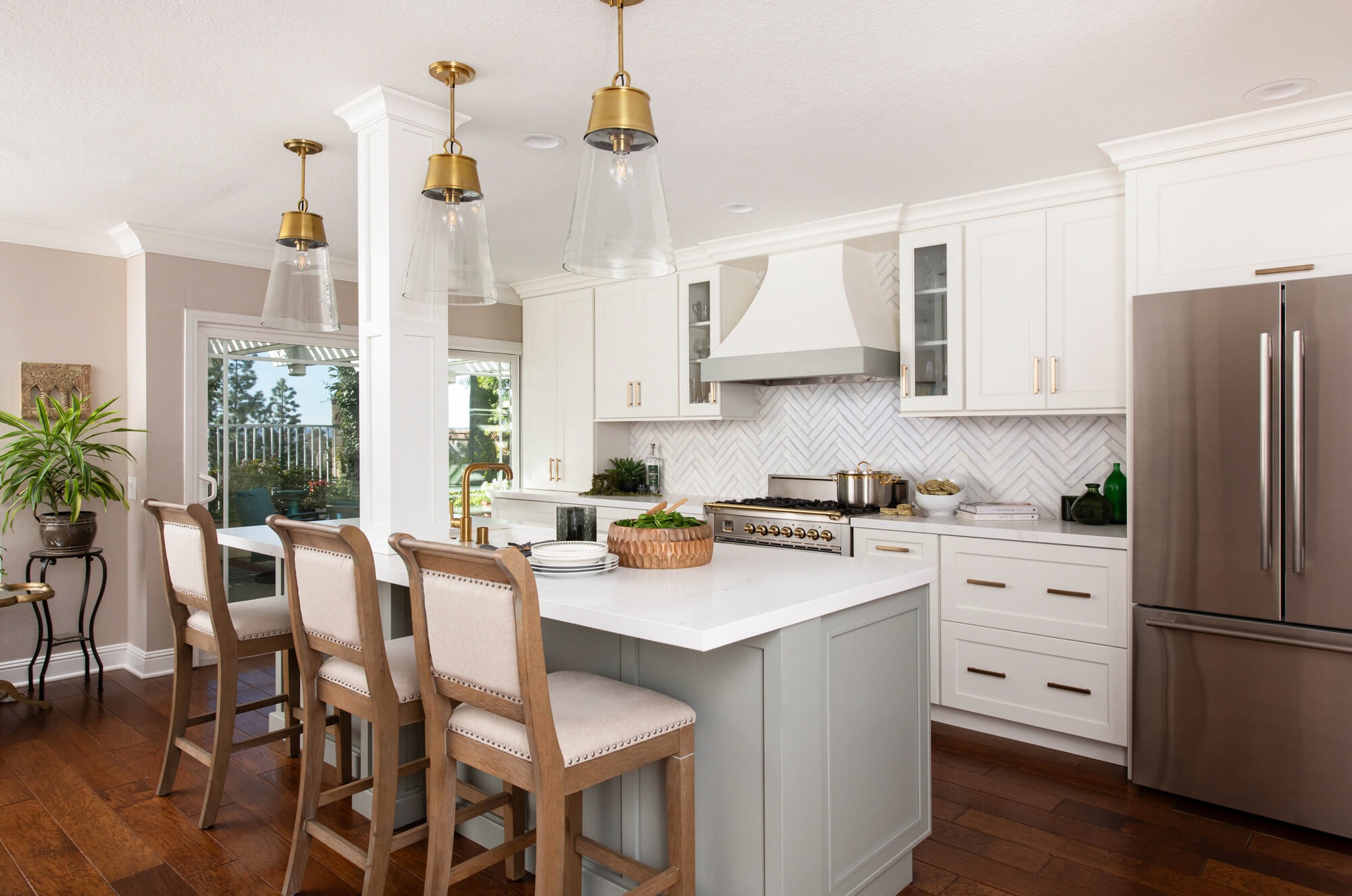 Bright and airy kitchen remodel in Canton GA with sage green island and brass pendants