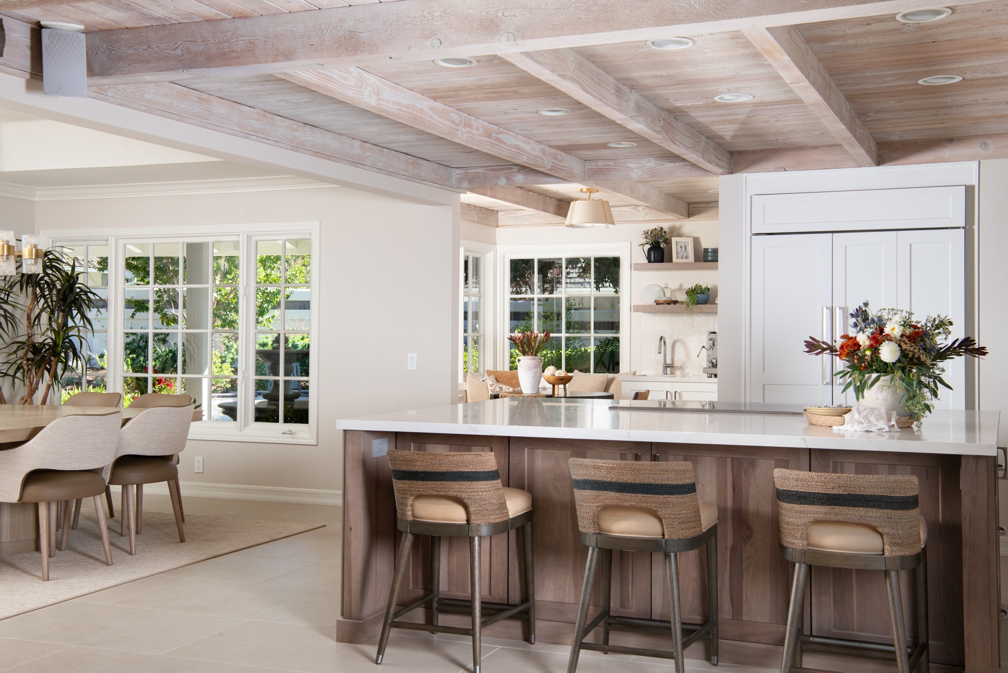 Kitchen with vaulted whitewashed beam ceiling and adjacent dining area