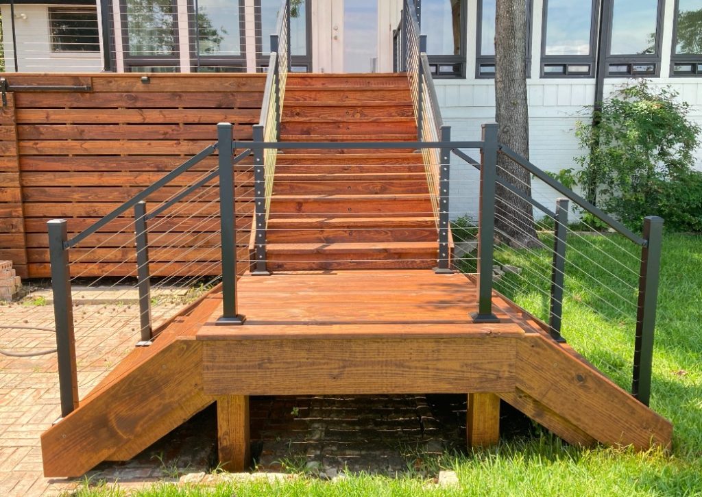 Stained deck stairs with black metal cable rail and wood planks at a Metro Atlanta home