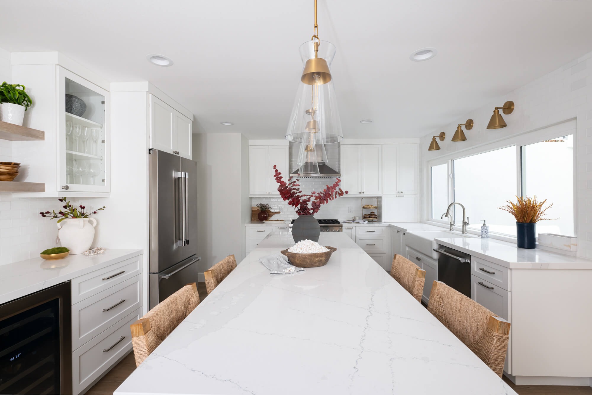 Luxury kitchen remodel in Sandy Springs with brass pendants and marble waterfall island