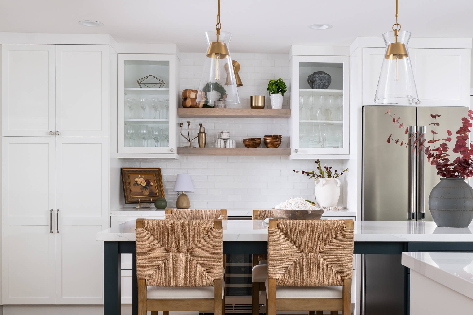 Open shelves and glass-front cabinets with navy peninsula in Sandy Springs kitchen