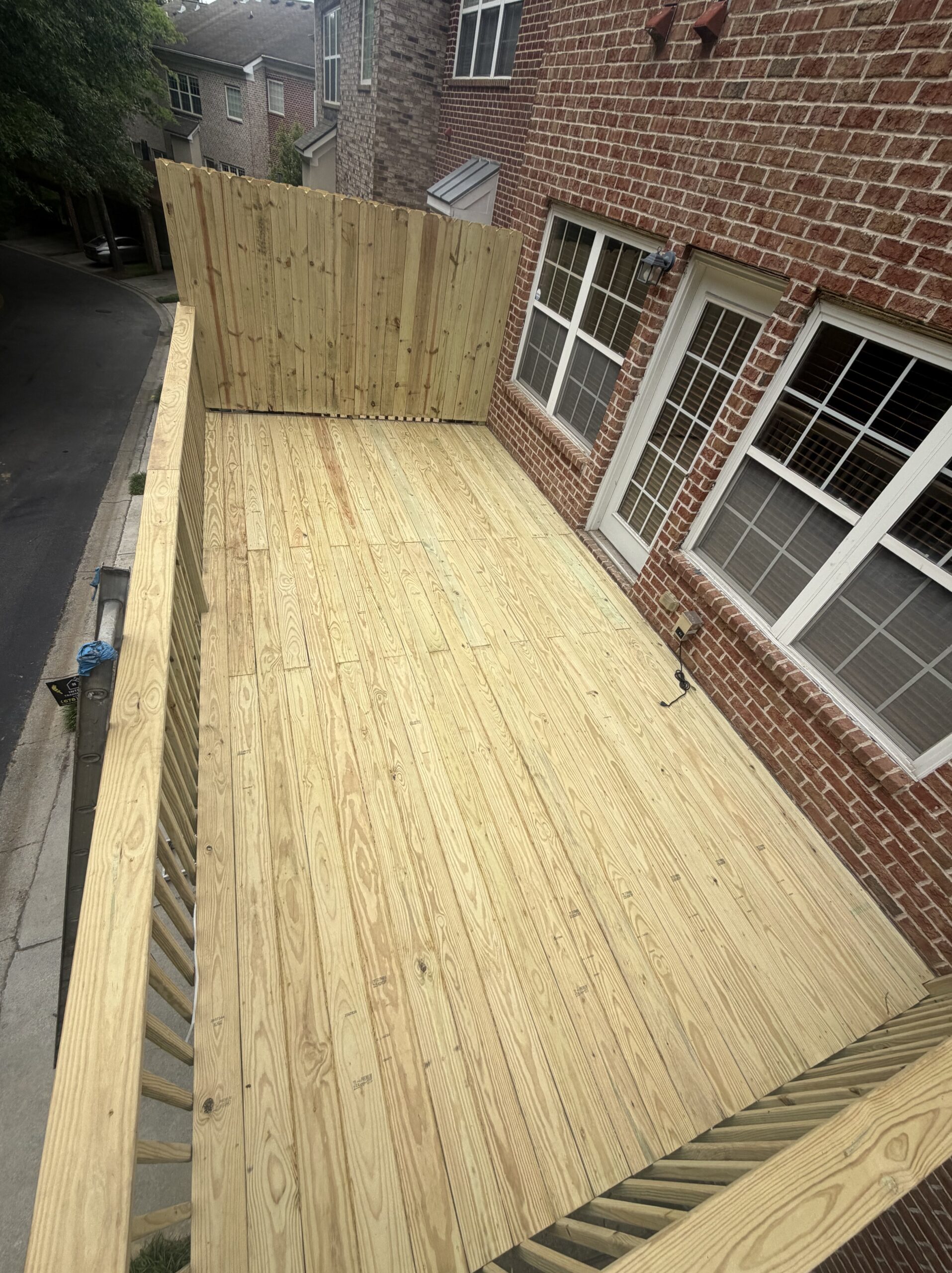 Fresh pressure-treated deck rebuild by Interior Transformation Remodeling in Metro Atlanta — top-down view of new boards, stairs, and railings